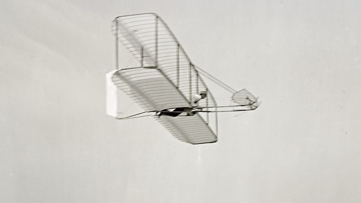 Wilbur Wright gliding above the sand at Kitty Hawk in 1902.